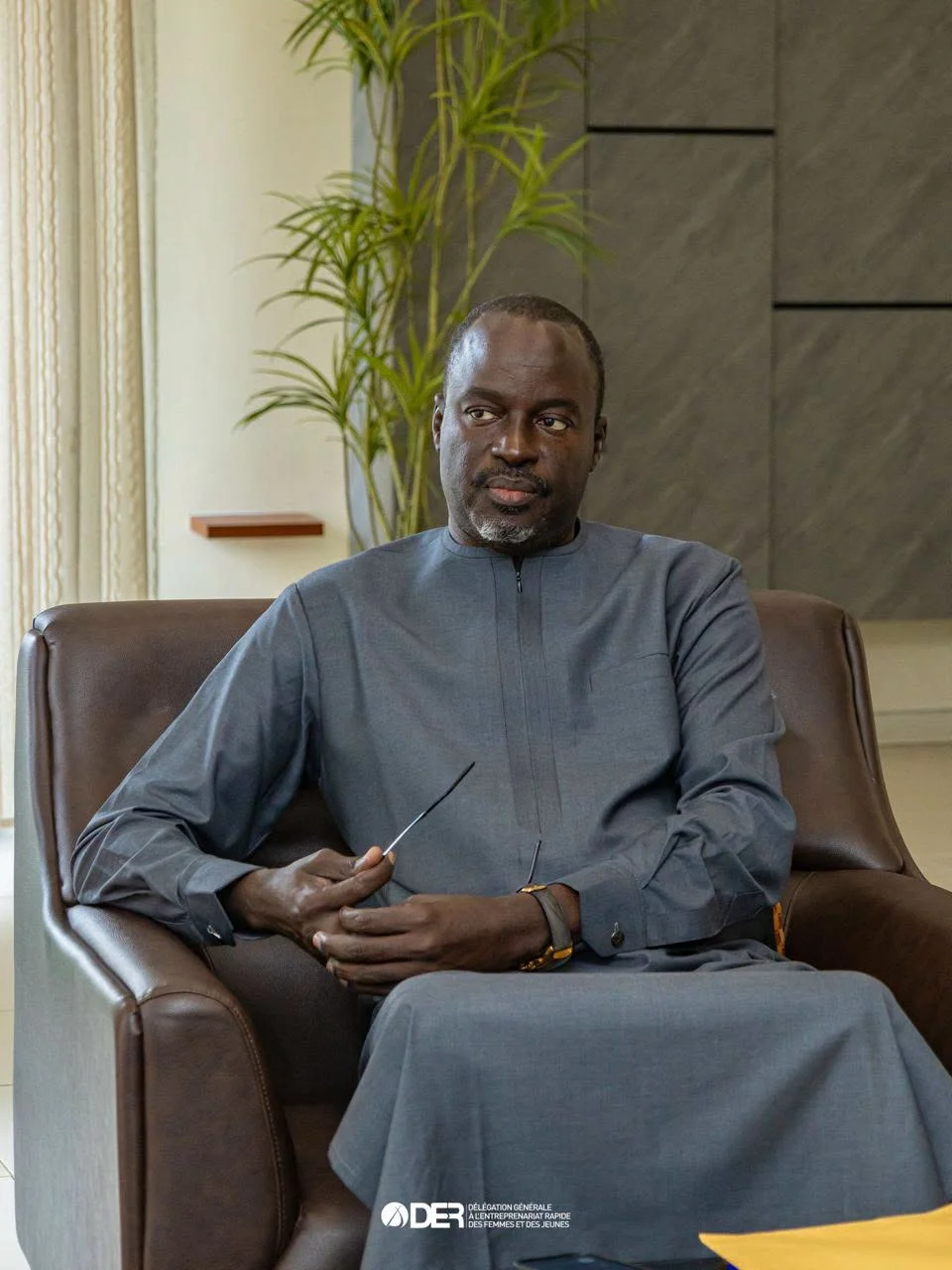 Docteur Abdoulaye Niane, assis en tenue grise